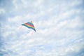 Young brunette woman, wearing casual clothes green t-shirt, playing with colorful kite on green field meadow in summer, running, Royalty Free Stock Photo