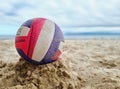 Colorful voley ball resting on the beach sand Royalty Free Stock Photo