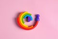 Colorful Waldorf wooden human figure rainbow in a montessori teaching pedagogy on pink background, kid play concept