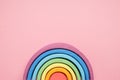 Colorful Waldorf wooden rainbow in a montessori teaching pedagogy on pink background