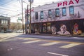 a colorful wall mural with Colin Kaepernick kneeling, Jimmy Carter, and a clown on a black brick wall in Atlanta Georgia