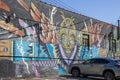 A colorful wall mural in Little Five Points surrounded by parked cars with a gorgeous clear blue sky in Atlanta Georgia
