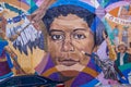 A colorful wall mural with Lorraine Hansberry in Little Five Points surrounded by parked cars with a gorgeous clear blue sky