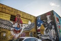 a colorful wall mural with a young black man with wings with a woman and a baby that reads Elevate and Educate and Dr Doris Derby