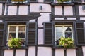 Colorful wall of old half-timbered house with multiple windows and wooden shutters Royalty Free Stock Photo