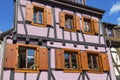 Colorful wall of old half-timbered house with multiple windows and wooden shutters