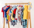 Dressing closet with clothes arranged on hangers.