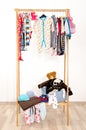 Dressing closet with baby clothes arranged on hangers.