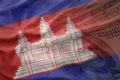 Colorful waving national flag of cambodia on a american dollar money background.