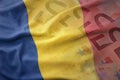 Colorful waving national flag of romania on a euro money banknotes background.