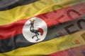 Colorful waving national flag of uganda on a euro money banknotes background.