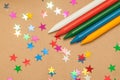 Colorful wax crayons and stars on kraft Royalty Free Stock Photo