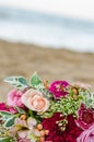 Colorful wedding bouquet from roses. Pink, red and green. Beach wedding. Royalty Free Stock Photo