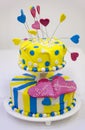 Colorful wedding cake - yellow, blue, pink - with white polka dots and hearts