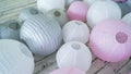 Colorful white pink gray paper lanterns set on floor.