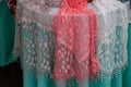 Colorful white and pink lace tablecloths hung and sold. Assortment of lace and embroidery. Royalty Free Stock Photo