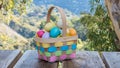 Colorful wicker Easter basket filled with Easter eggs on a picnic table outdoors