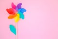 colorful wind turbine or pinwheel toy on pink background