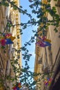 Colorful windmills and flowers decorations against the blue sky on a narrow street with old buildings in Bucharest, Romania Royalty Free Stock Photo