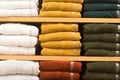 Colorful winter coats folded and orderly stacked on a shelf