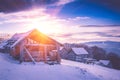 Colorful winter sunrise in the mountains. Fantastic morning glowing by sunlight. View of the snowy forest and old wooden hut cabin Royalty Free Stock Photo