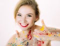 Colorful woman portrait in paint with red lips making thumbs up