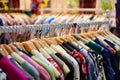 Colorful women`s dresses on hangers in a retail shop