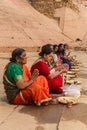 Colorful women sitting and praying at the ghats in Varanasi