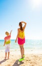 Modern mother and child on beach throwing stones