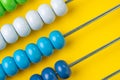 Colorful wooden abacus beads on yellow background, business financial or accounting cost and expense calculation concept, or use