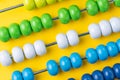 Colorful wooden abacus beads on yellow background, business financial or accounting profit and loss concept, or use in education Royalty Free Stock Photo