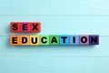 Colorful wooden blocks with phrase `SEX EDUCATION` on light blue background