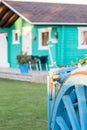 Colorful wooden bungalow with old blue wooden wagon. Royalty Free Stock Photo