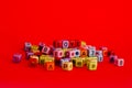Colorful wooden cube beads with letters on red festive background word \