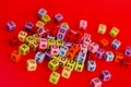 Colorful wooden cube beads with letters on red festive background  word \