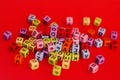 Colorful wooden cube beads with letters on red festive background word \