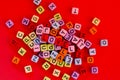 Colorful wooden cube beads with letters on red festive background word \