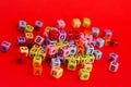 Colorful wooden cube beads with letters on red festive background word \