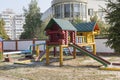 Colorful wooden house with slider on empty playground Royalty Free Stock Photo