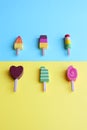 Colorful wooden ice cream over a pastel background.