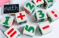 Colorful wooden math cubes with numbers, notebook on pink white background. Interesting, fun mathematics for kids. Education Royalty Free Stock Photo