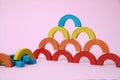 Colorful wooden pieces of playing set on pink background. Educational toy for motor skills development Royalty Free Stock Photo