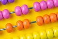 Colorful wooden pink and orange abacus beads on yellow background, business financial or accounting profit and loss concept, or u Royalty Free Stock Photo