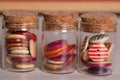 Multicolored wooden round sewing buttons in small jars macro shot. Royalty Free Stock Photo