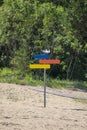 Colorful wooden signpost of directions on a sand beach. Royalty Free Stock Photo