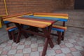 Colorful wooden table for piknic outside with two benches near the house. Comfortable place and rainbow colors let have Royalty Free Stock Photo