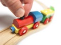 Colorful wooden toy train with hand isolated on white