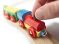 Colorful wooden toy train with hand isolated on white Royalty Free Stock Photo