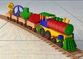 Colorful wooden toy train. Wooden train on the rails bearing in the wagons the symbols of love, health, peace and money for the ne Royalty Free Stock Photo