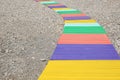 Colorful wooden walkway on pebble beach. Space for text